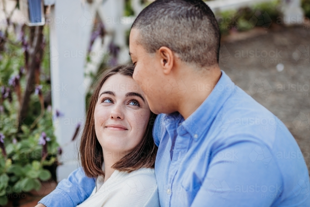 smiling lgbtqi couple looking at one another - Australian Stock Image