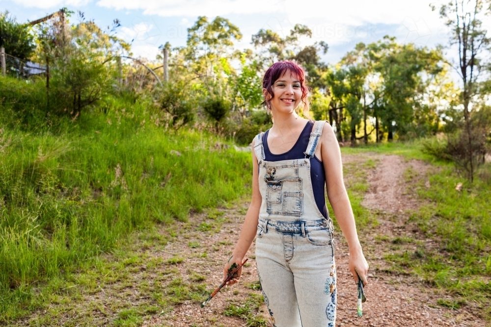 Smiling portrait of teenage young lady in overalls - Australian Stock Image