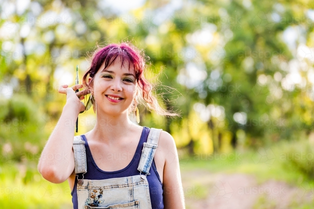 Smiling portrait of teenage young lady in overalls - Australian Stock Image