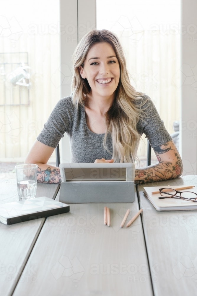 Smiling successful young business woman working at at home - Australian Stock Image
