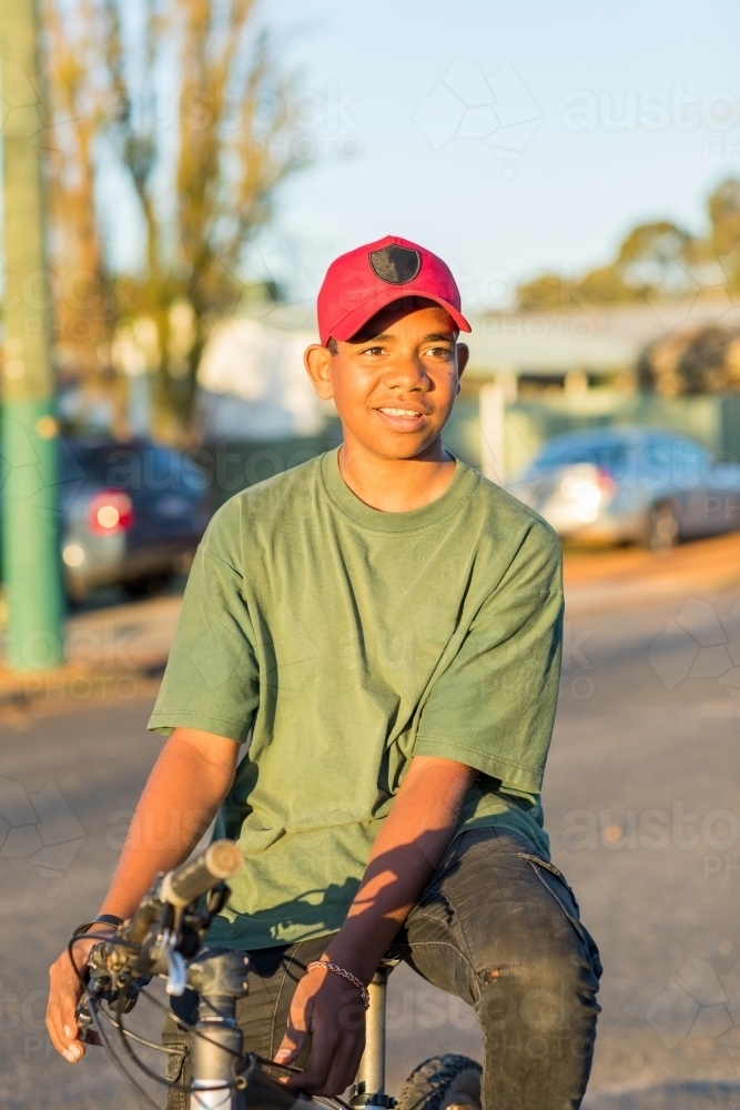 smiling teenage boy sitting on mountain bike - Australian Stock Image