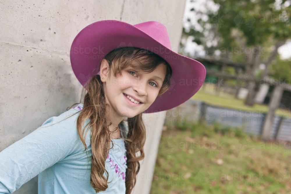 Smiling tween girl in a pink cowgirl hat - Australian Stock Image