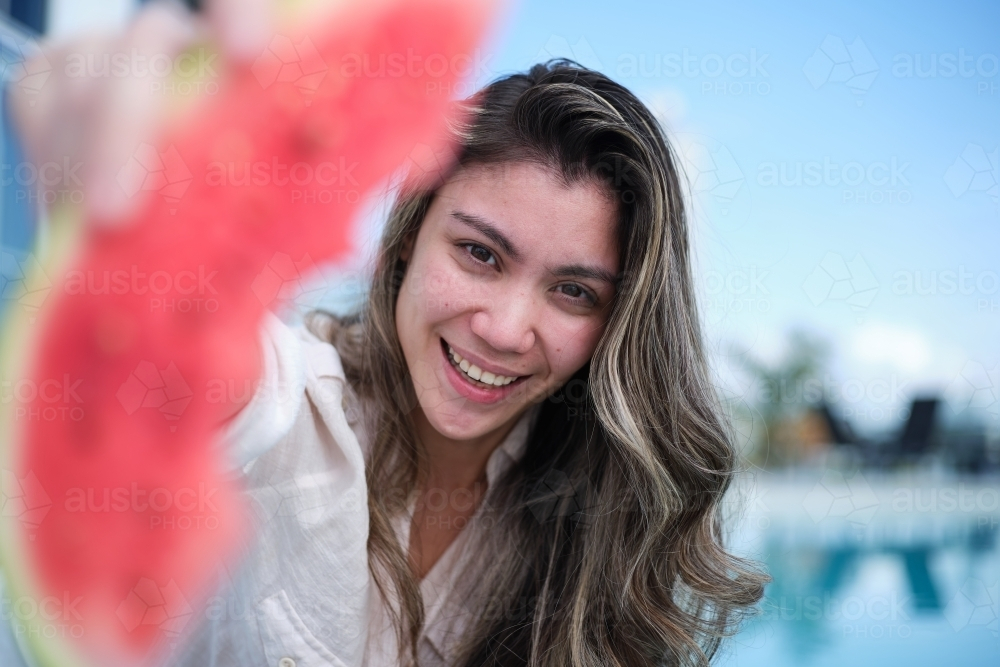 Smiling woman holding watermelon slice - Australian Stock Image