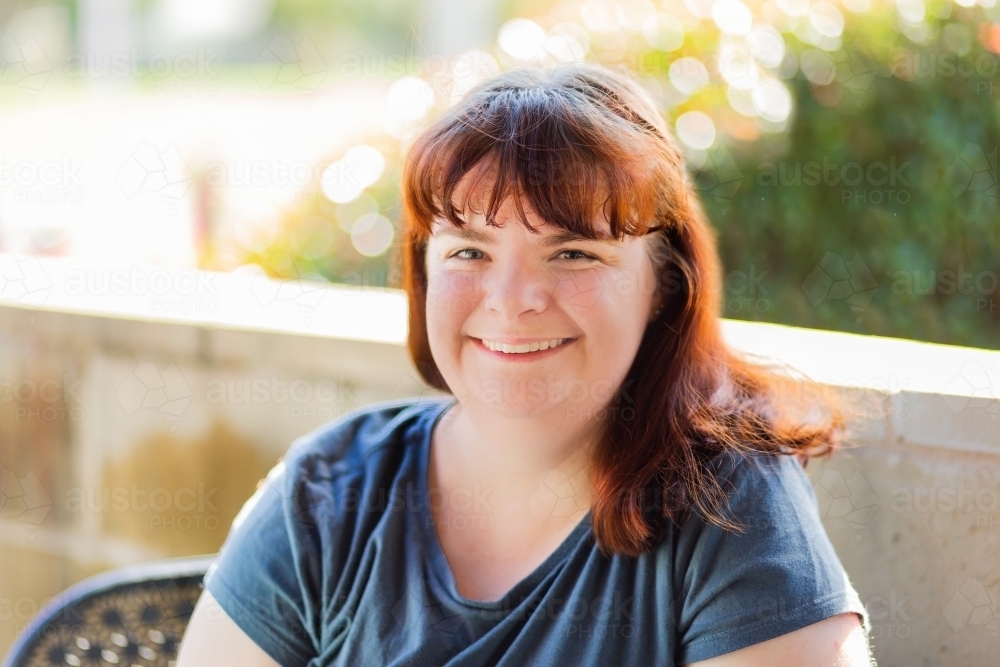 Smiling woman sitting outside at a café - Australian Stock Image