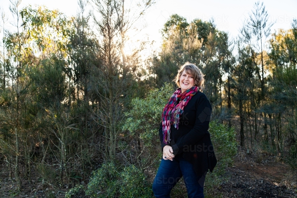 Smiling woman wearing bright scarf in winter - Australian Stock Image