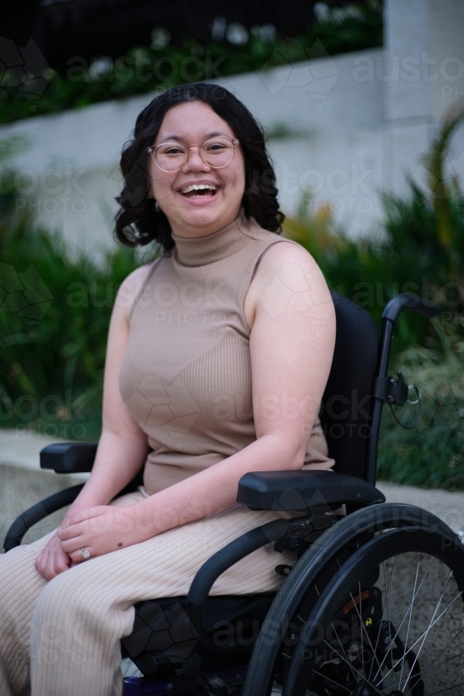 Image of Smiling woman with disability sitting in a wheelchair outside ...