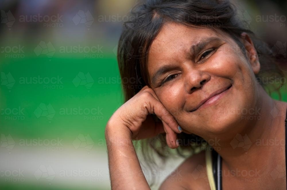 Smiling Woman with Head Leaning on Back of Hand - Australian Stock Image