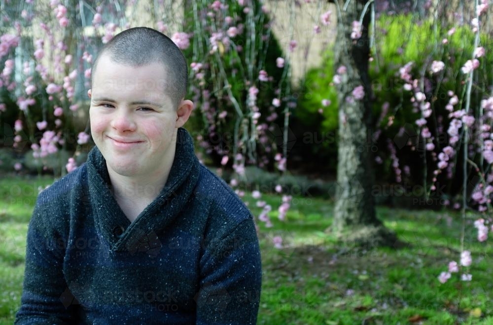 Smiling Young Man seated in his Front Garden - Australian Stock Image