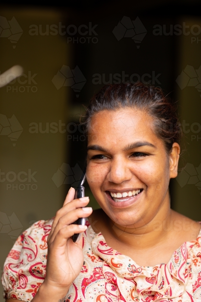 smiling young woman talking on flip-phone - Australian Stock Image
