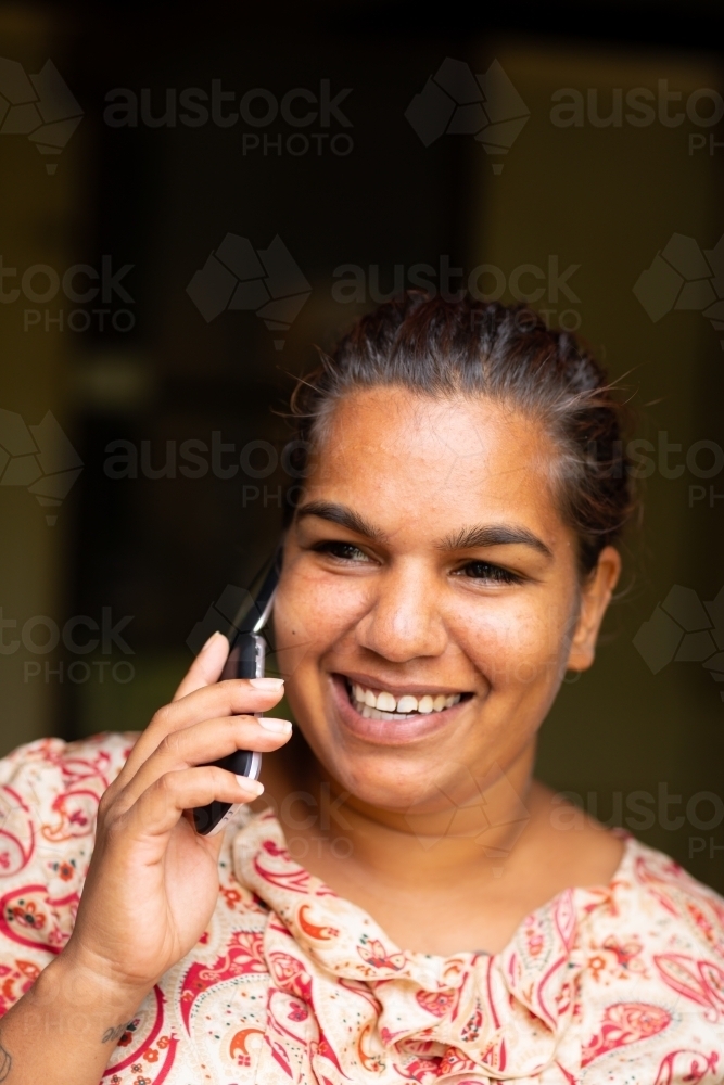 smiling young woman talking on flip-phone - Australian Stock Image