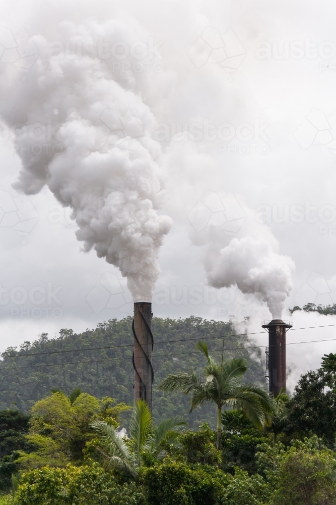 Smoke billowing out of smokestacks at a sugar refinery - Australian Stock Image