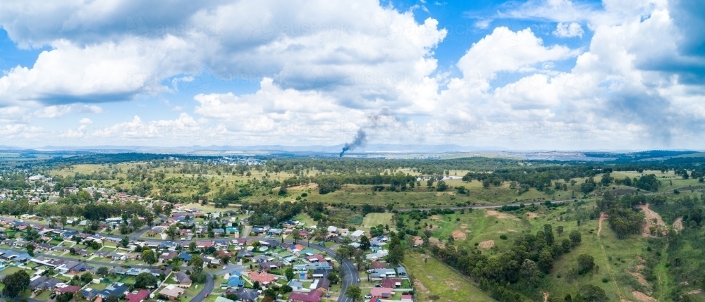 Smoke on horizon from distant house fire outside of town - Australian Stock Image