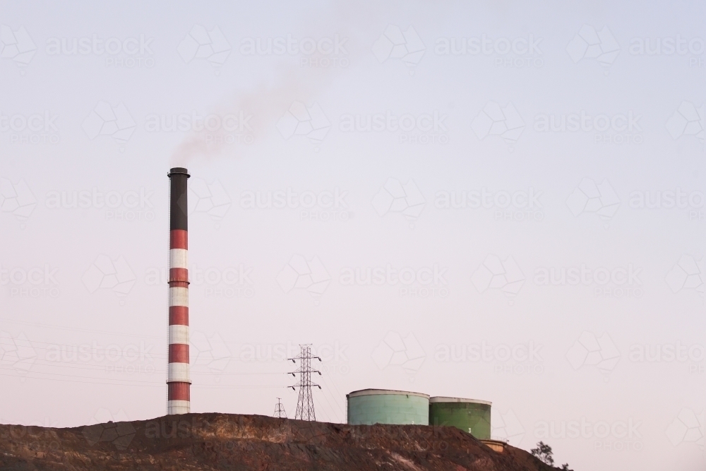 Smoke stack and water tanks at a regional town - Australian Stock Image