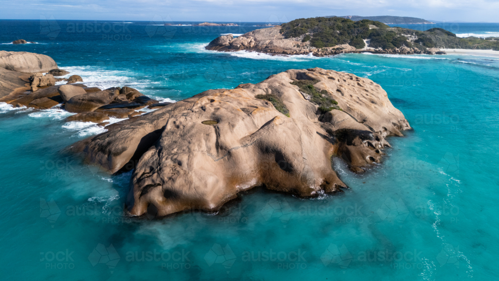 Smooth rounded boulders in a turquoise sea - Australian Stock Image
