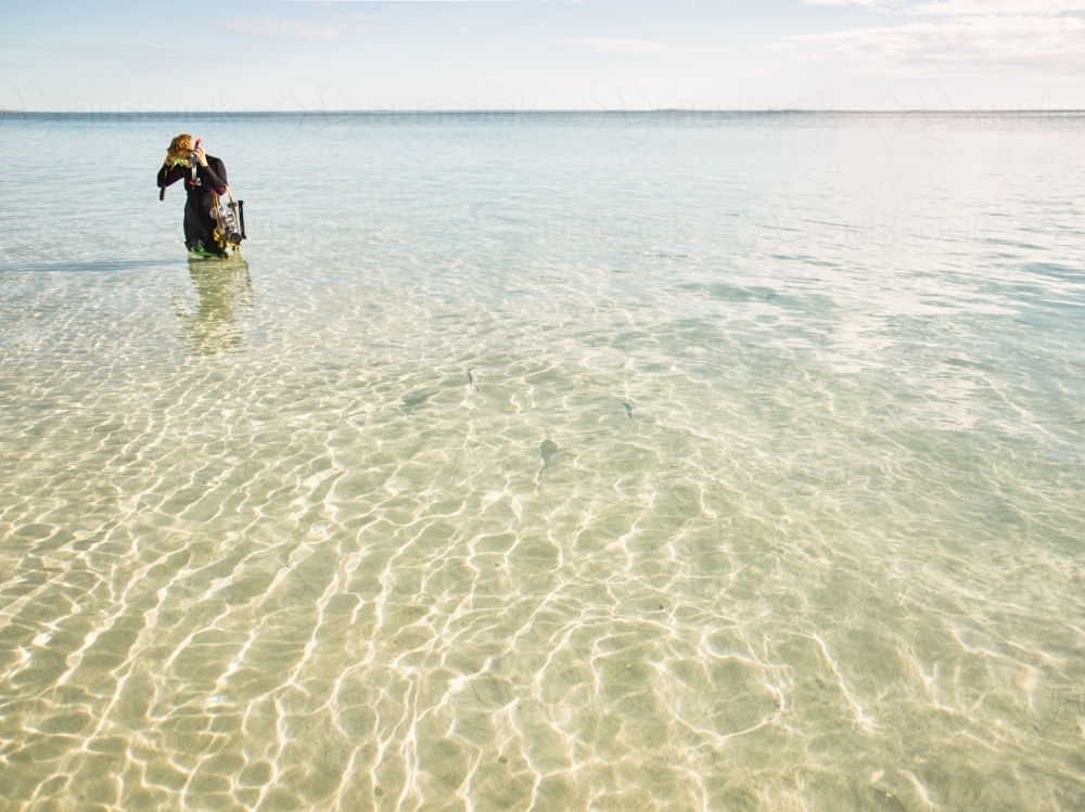 Snorkeler adjusting goggles in shallow water - Australian Stock Image