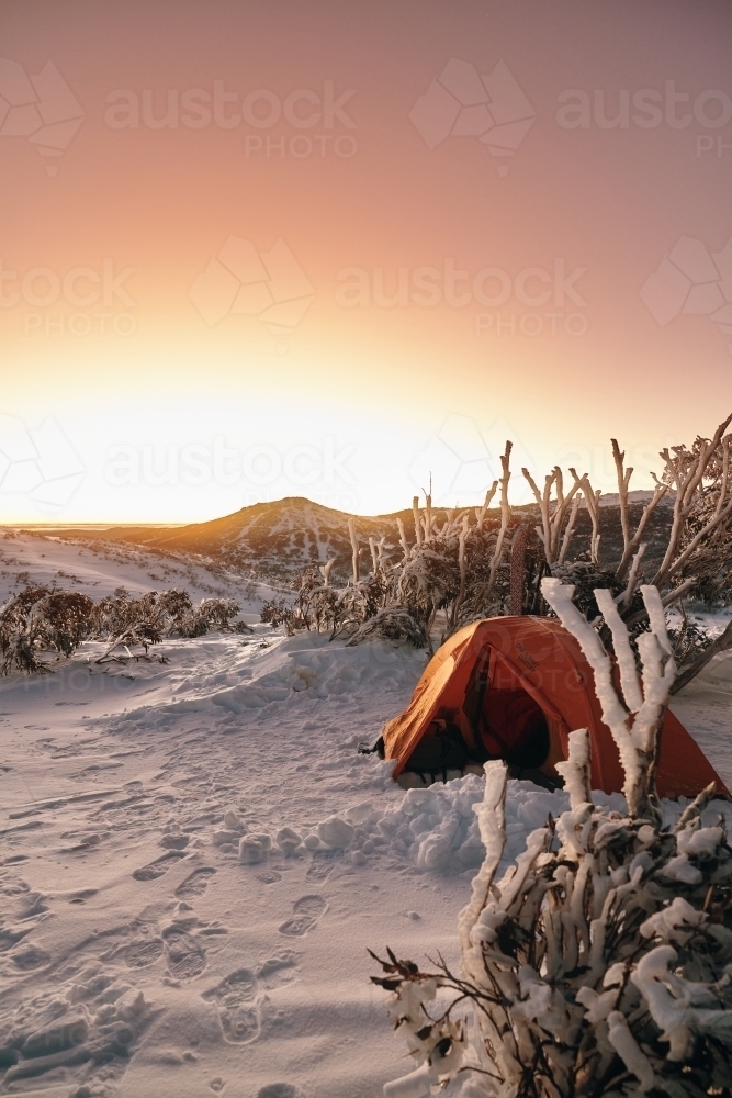 Snow camping in the backcountry at sunrise in winter - Australian Stock Image