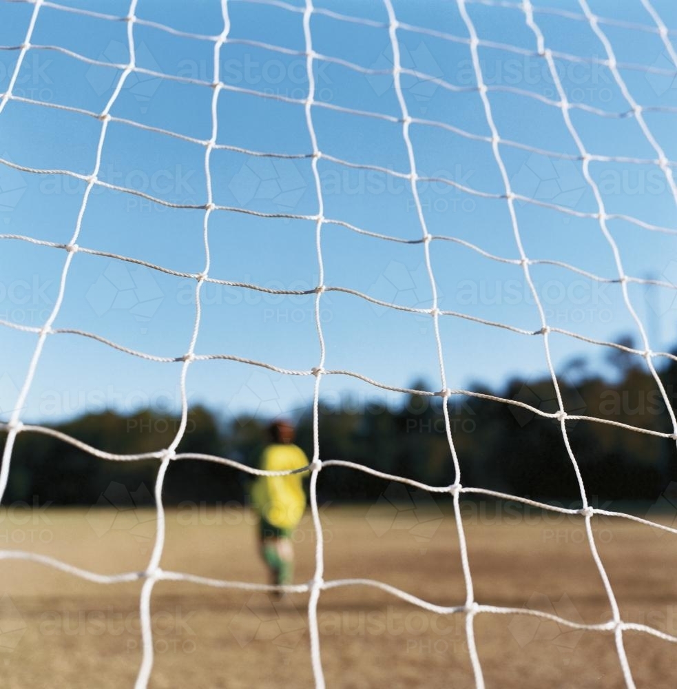 Soccer Football net with blurry goal keeper - Australian Stock Image