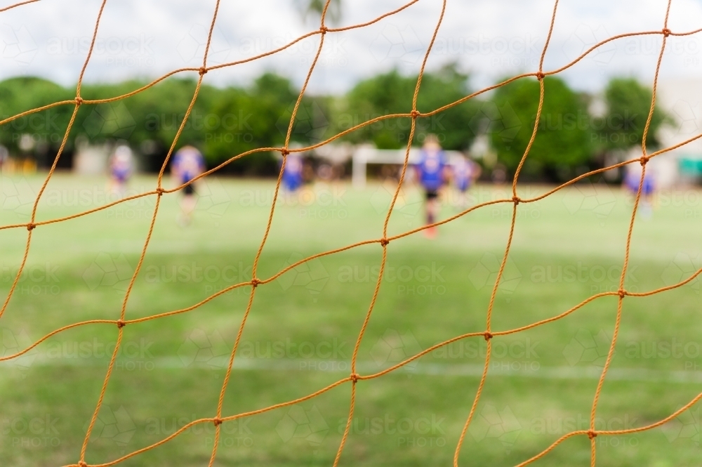 Soccer net with blurry players - Australian Stock Image