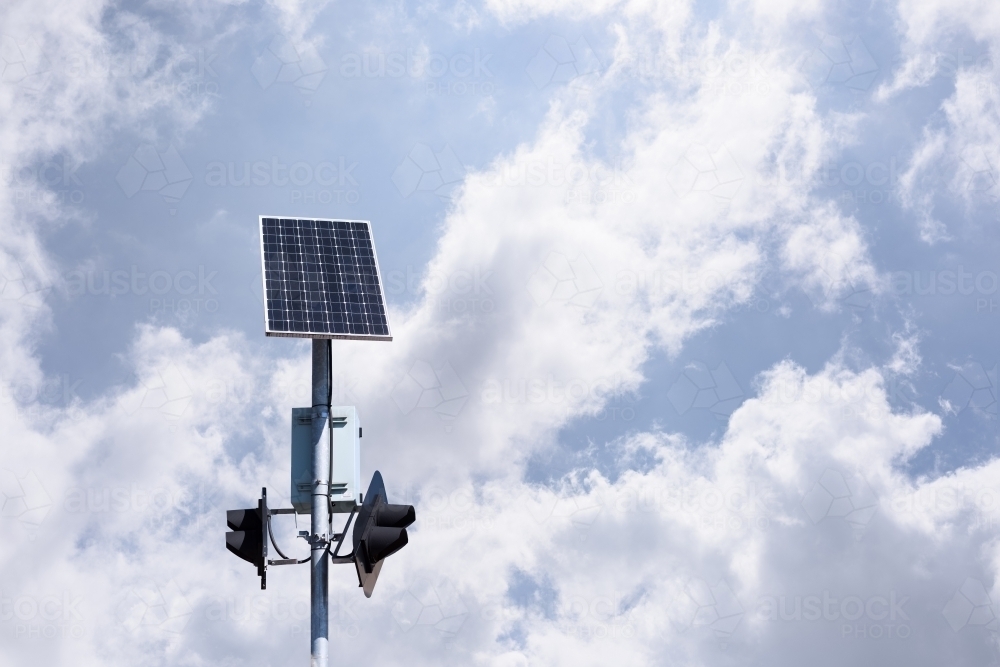 Solar panel powered traffic light against blue sky background, clean energy in use, in Melbourne - Australian Stock Image