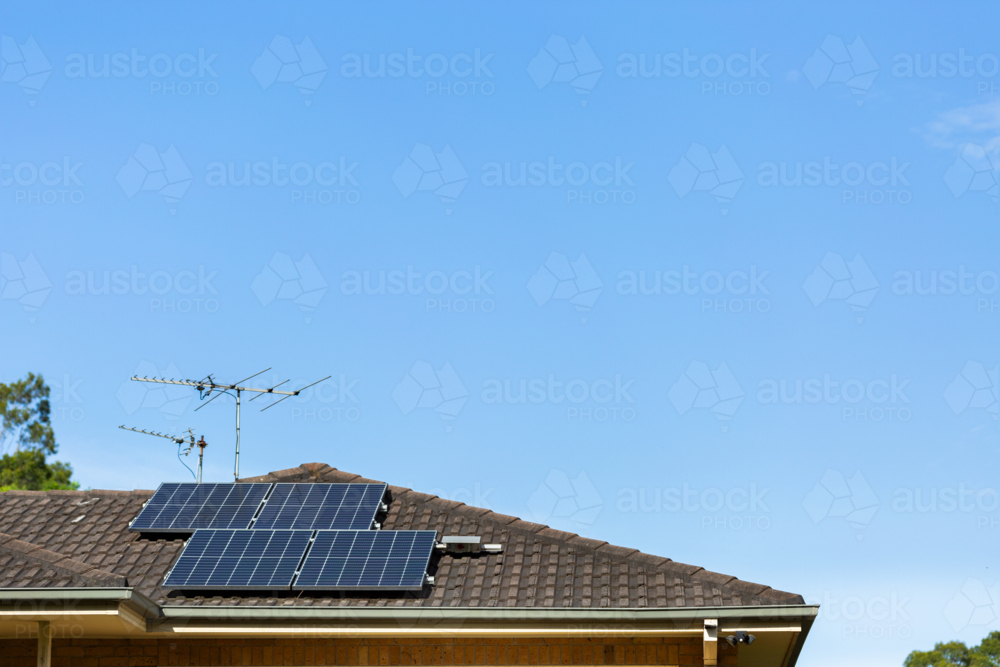 Solar panels and aerial on roof with blue sky copy space - Australian Stock Image