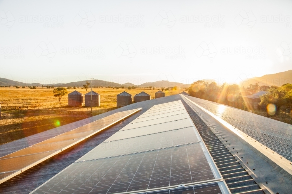 Solar panels on a shed roof generating energy with sunlight lens flare - Australian Stock Image