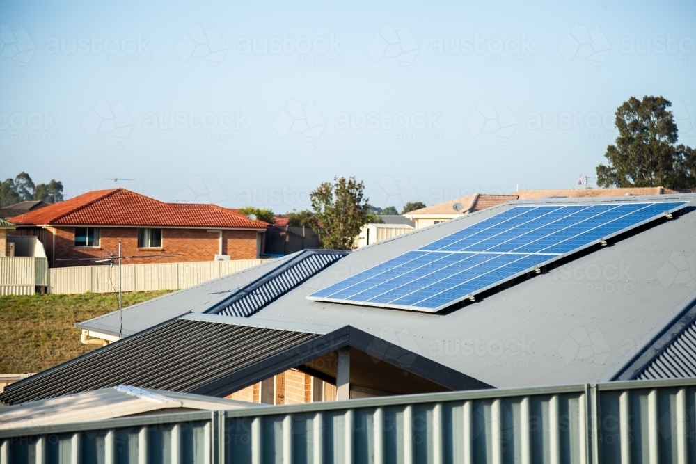 Image of Solar panels on home roof in town with blue sky copy space ...