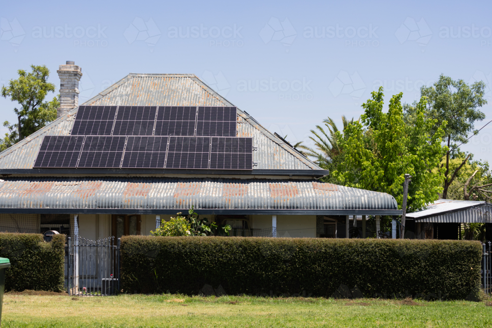 Solar panels on the roof of an older Australian house with bull nose verandah - Australian Stock Image