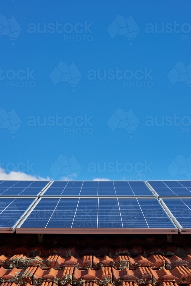 Solar panels on tile roof under blue skies - Australian Stock Image