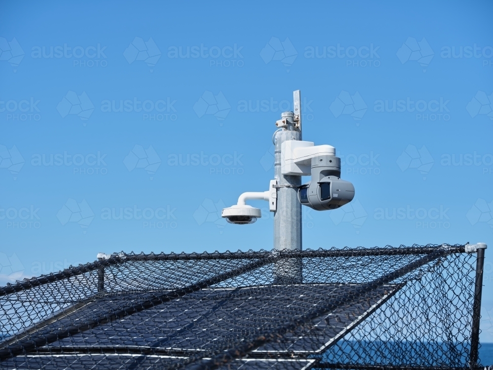Solar panels with fences and a post with a light and camera - Australian Stock Image