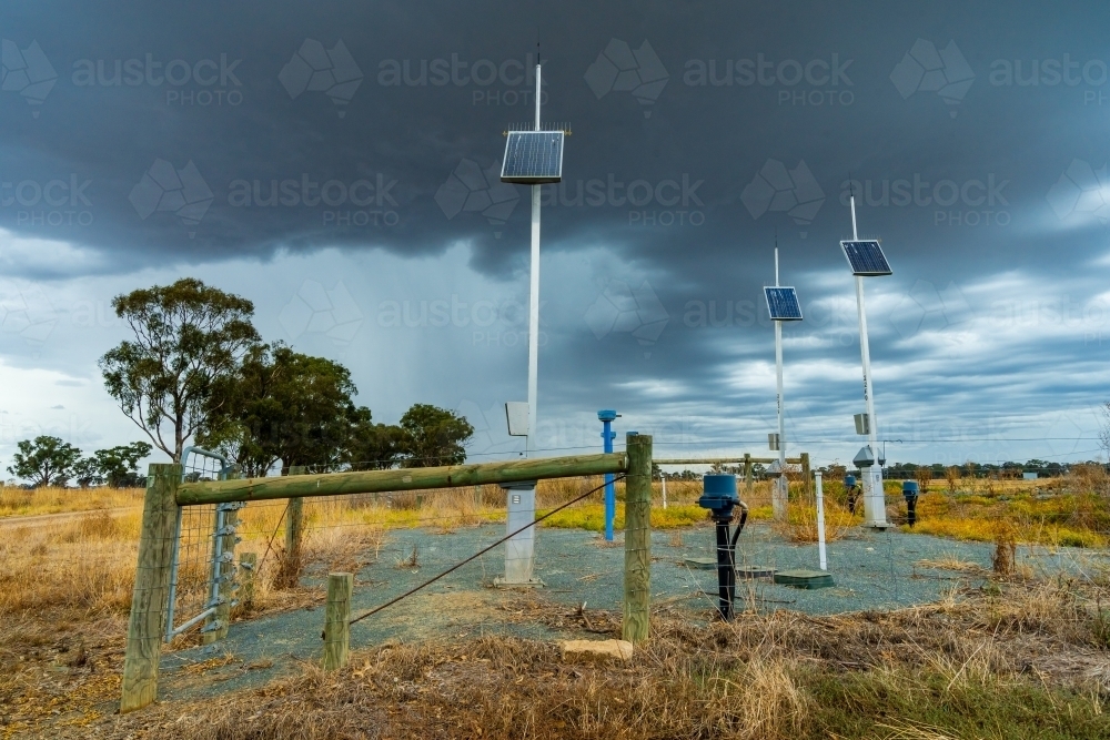 Solar powered irrigation control towers under storm clouds - Australian Stock Image