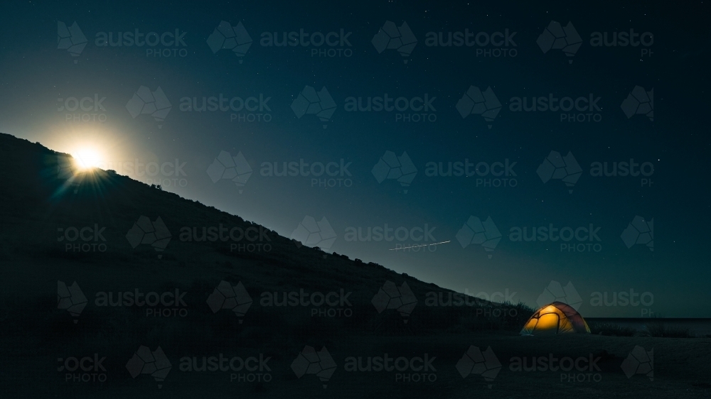 Solo Camping on a full moon's night in a tent - Australian Stock Image