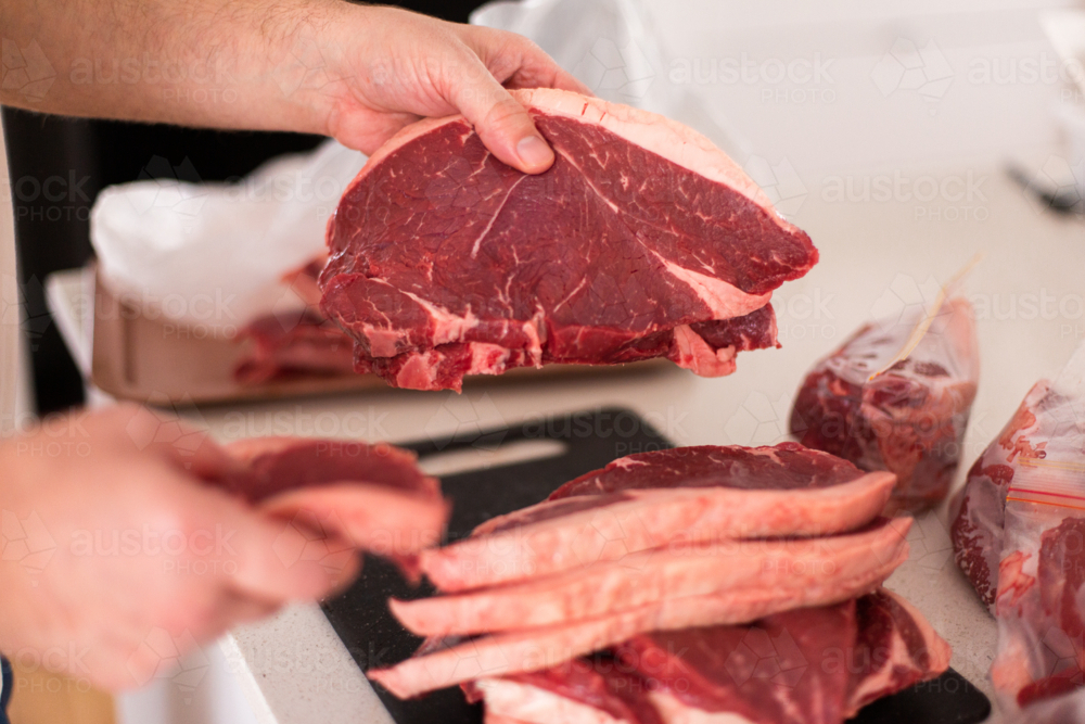 sorting a bulk meat purchase into meal sized portions - Australian Stock Image