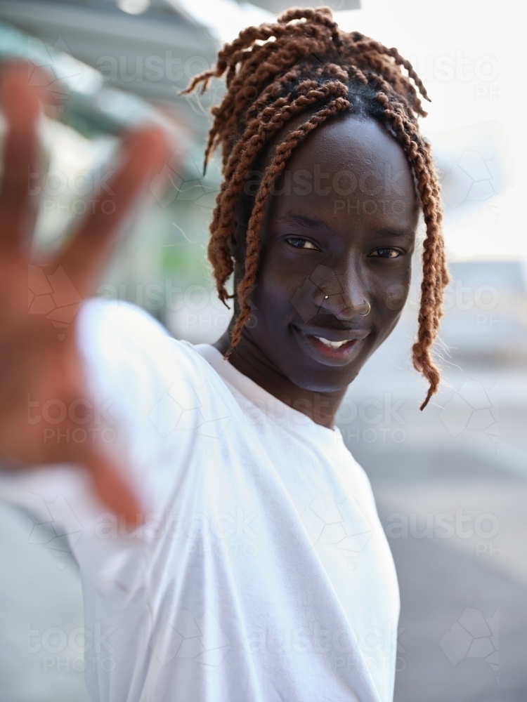 South Sudanese man reaching palm towards the camera - Australian Stock Image