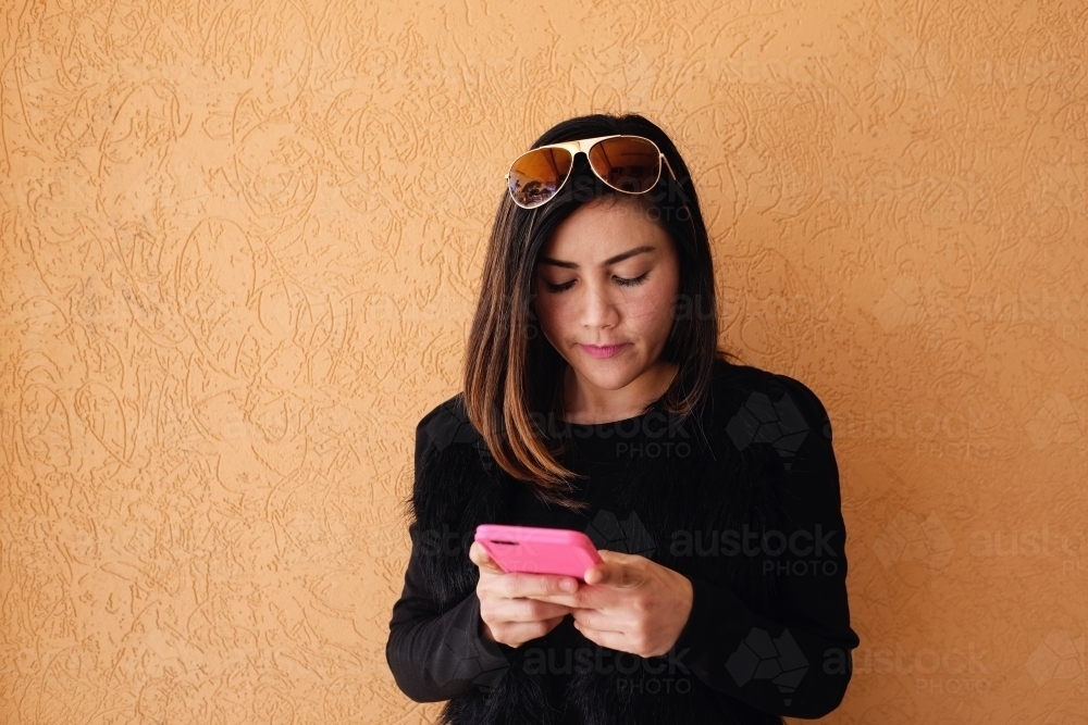 Southeast Asian multicultural woman using mobile phone - Australian Stock Image