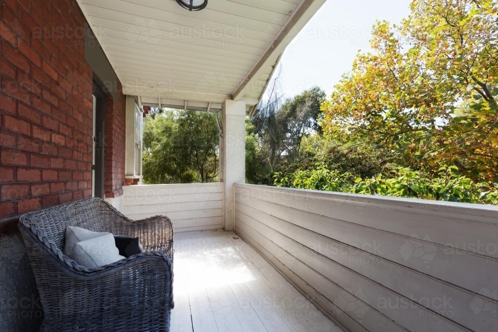 Spacious apartment balcony with view to the tree tops from cane wicker seat - Australian Stock Image