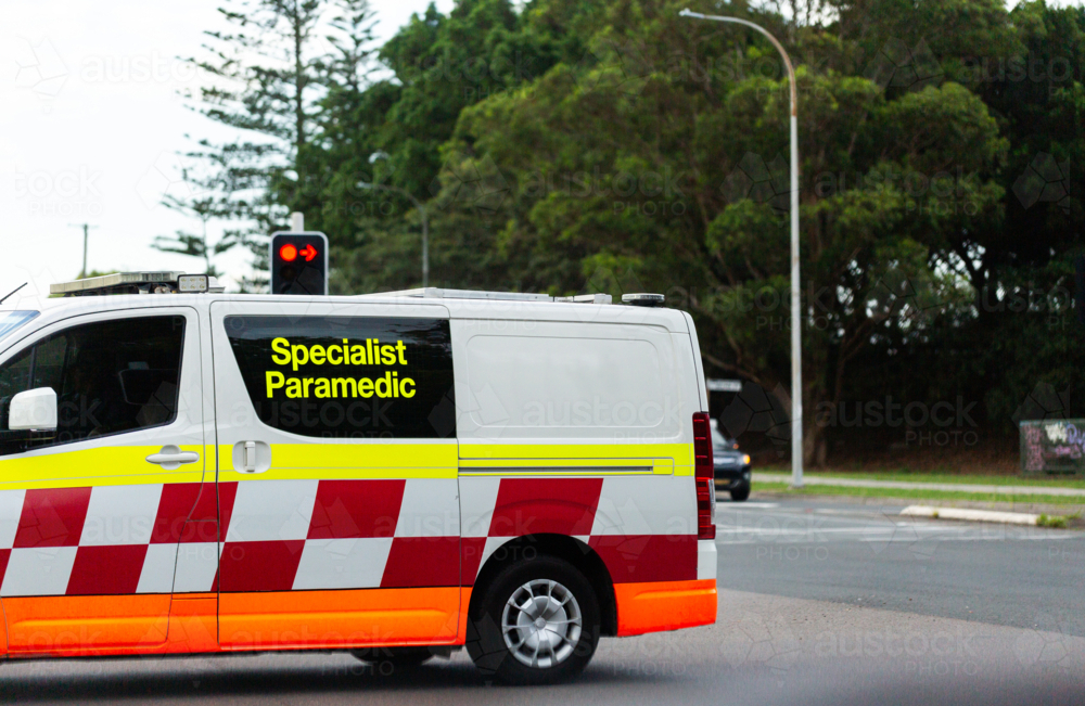 specialist paramedic ambulance vehicle passing at intersection on street - Australian Stock Image