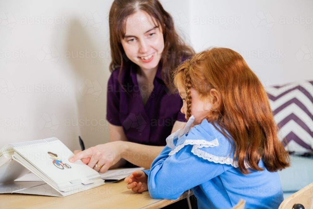 Speech pathologist working with child and sound book - Australian Stock Image