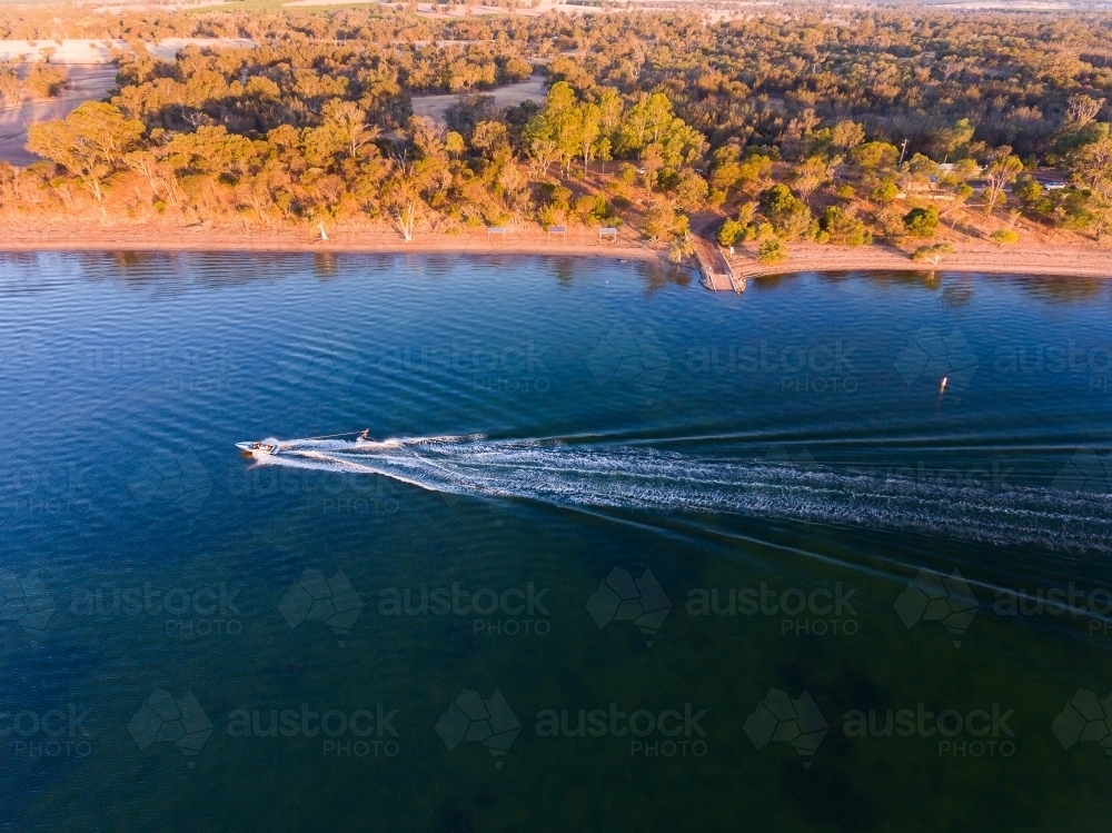 speedboat towing skier on Lake Towerrinning with land in background - Australian Stock Image