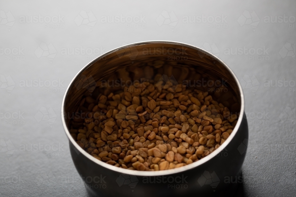 Spice tin of fenugreek seeds - Australian Stock Image