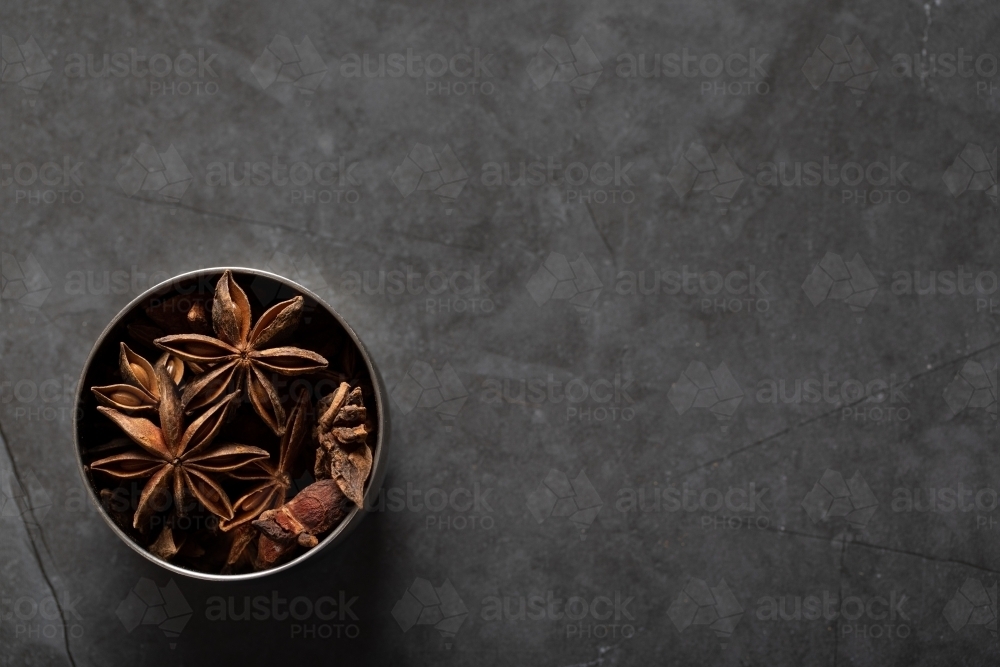 Spice tin of star anise on dark marble background - Australian Stock Image