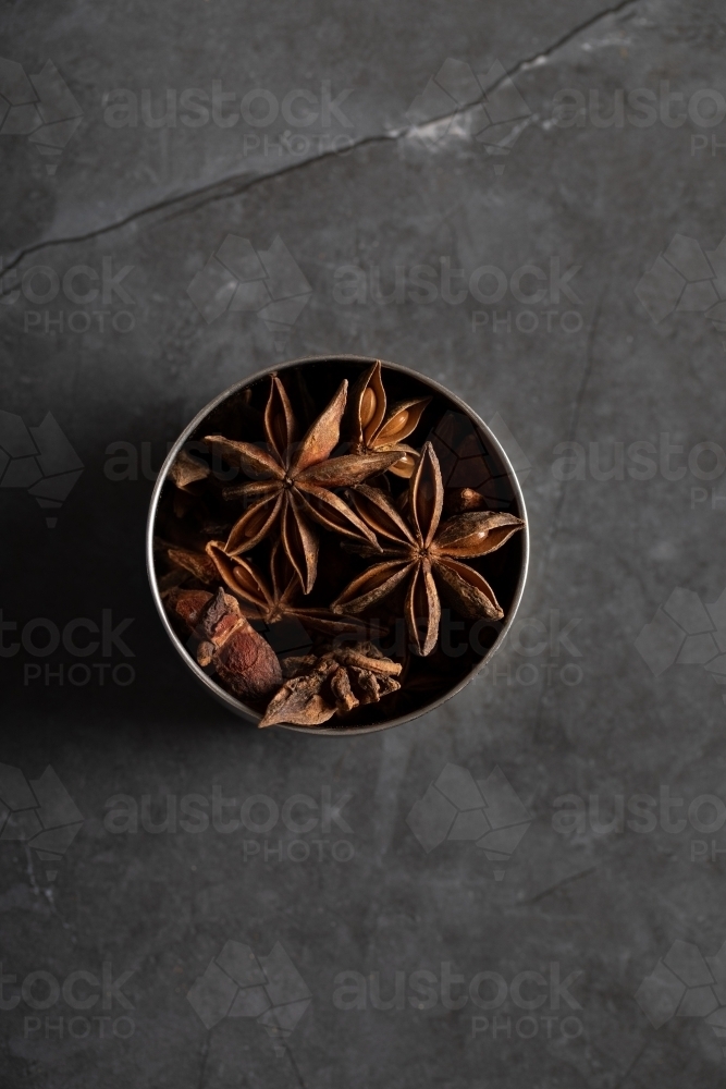 spice tin of star anise on dark marble background - Australian Stock Image