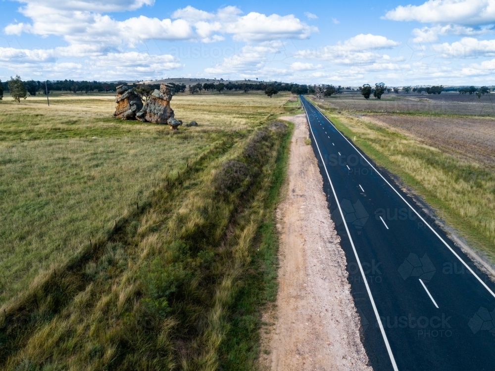 Split rock with tree growing in it beside Golden Highway - Australian Stock Image