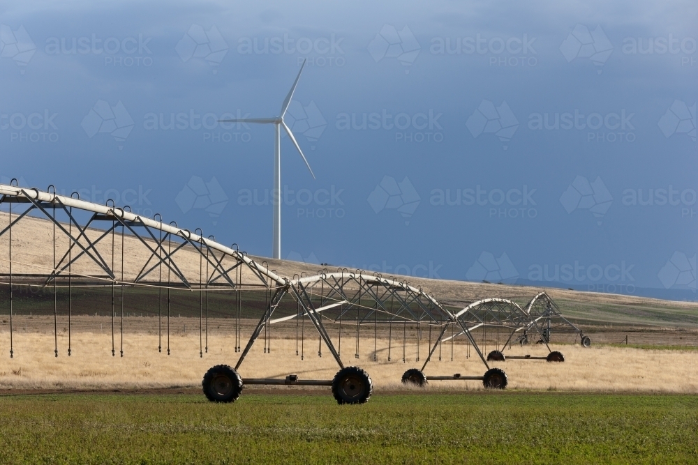 Sprayer on paddock with crops with wind turbine in background - Australian Stock Image