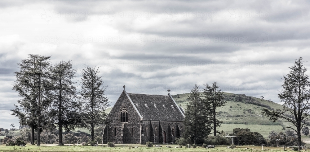 st Josephs Bluestone catholic church in a pictureque rural setting at the base of a hill - Australian Stock Image