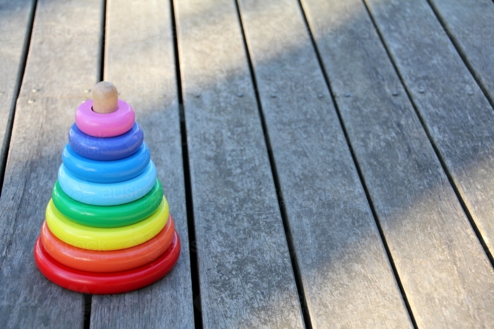 Stack of coloured rings on timber deck - Australian Stock Image