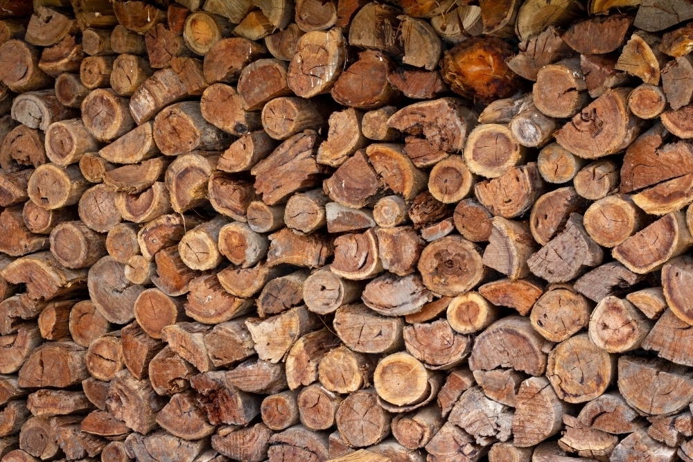stack of logs against wall - Australian Stock Image