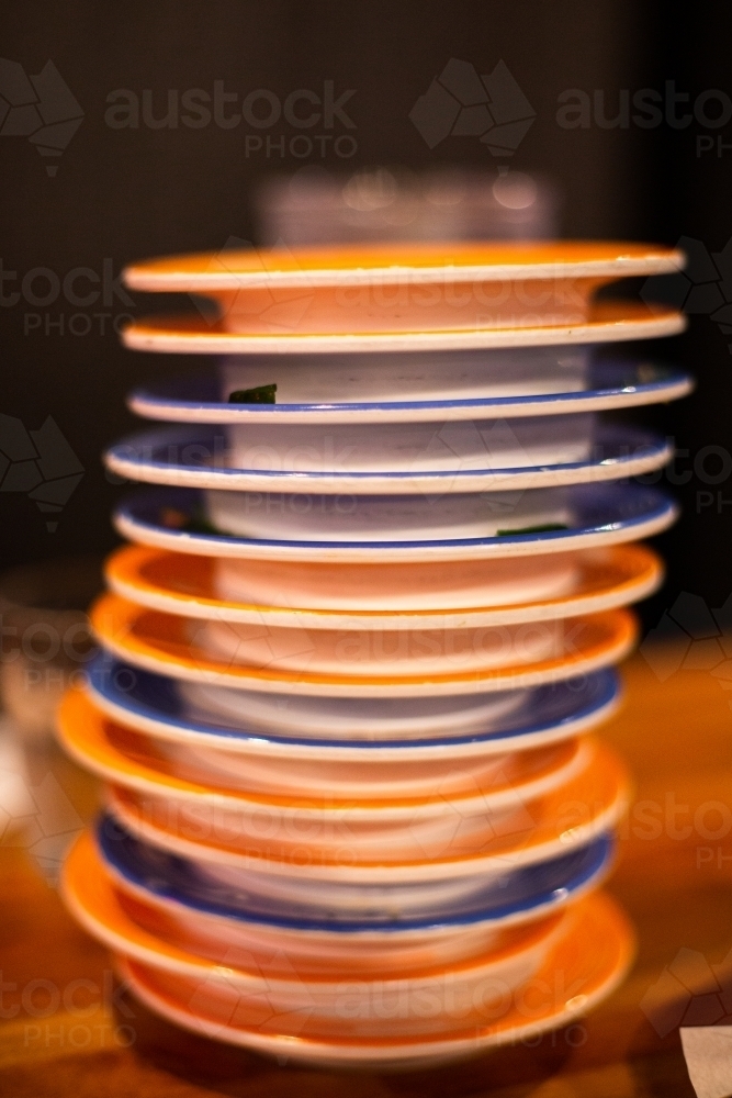 stack of plates after dining at a sushi restaurant - Australian Stock Image