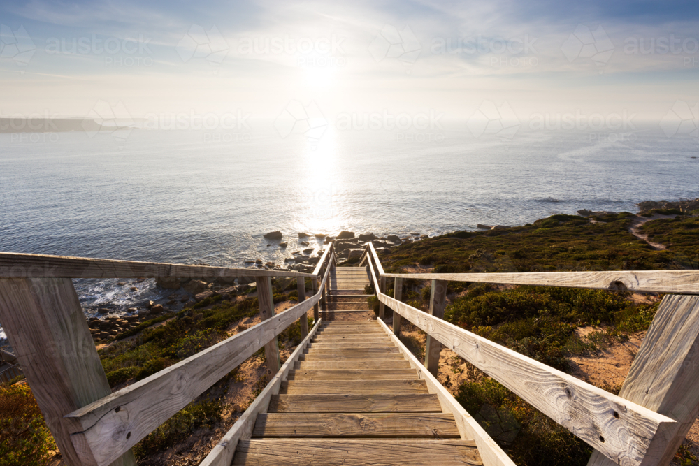 Stairs on walking trail leading to beautiful coastline, ocean and sunrise in South Australia - Australian Stock Image