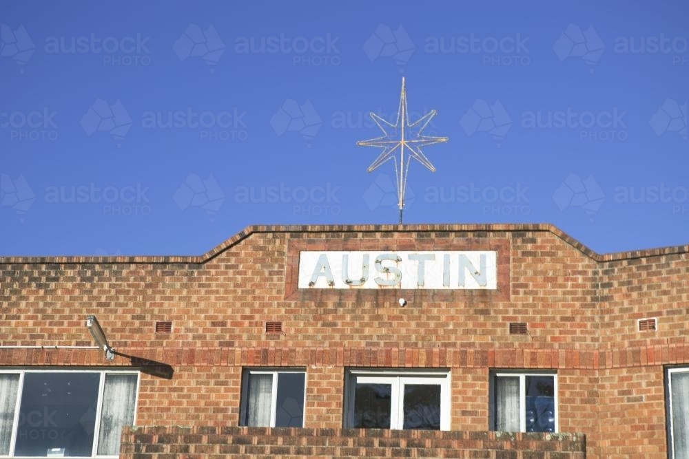 Star and Austin sign on top of old brick unit block - Australian Stock Image