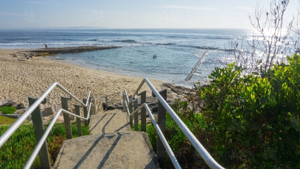 Steps and handrails leading down to beach and Oak Park ocean pool - Australian Stock Image